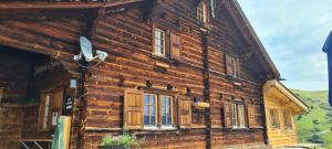een oud houten huis in de bergen bij Skihaus Hochwang in Arosa