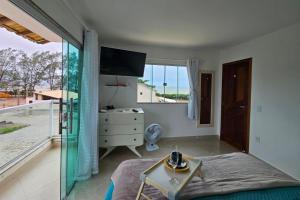 a bedroom with a bed and a view of the ocean at Casa de Praia frente pro Mar Marataízes in Saco dos Cações