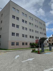 a large building with a parking lot in front of it at Hotel Centro Fashion in Fortaleza