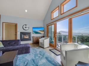 a living room with a couch and a fireplace at Shoreline Solace: Ocean View Townhouse Tillamook in Tillamook