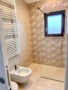 a bathroom with a toilet and a sink and a window at Villa Afrodite in San Pietro in Bevagna +14 photos