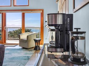 een koffiezetapparaat op een aanrecht in een kamer met een raam bij Shoreline Solace: Ocean View Townhouse Tillamook in Tillamook