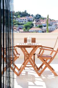 a wooden picnic table and two chairs on a roof at Agava Apartments in Sutivan