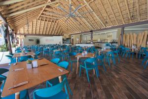 a dining room with wooden tables and blue chairs at Nirú Ocean Suites by Binniguenda in Santa Cruz Huatulco