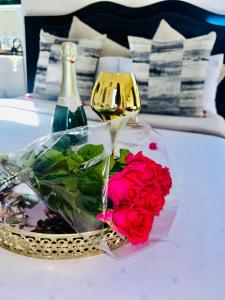 a bottle of wine and a bouquet of red roses at Skyfly Bed & Breakfast in Manzini