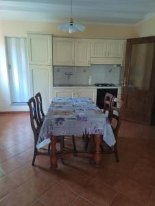 a kitchen with a table and chairs with a tablecloth at podere il poggetto in Lorenzana