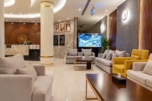 النخيل بارك للشقق المخدومة في الرياض: غرفة معيشة مع كنب وتلفزيون