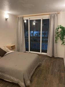 ein Schlafzimmer mit einem Bett und einem großen Fenster in der Unterkunft Posada Colón in Toluca de Lerdo