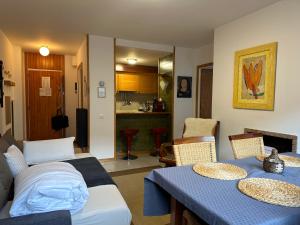 a living room with two tables and a kitchen at Morera Pas de la Casa, Andorra in Pas de la Casa
