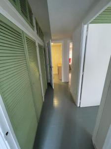 an empty hallway with green garage doors and a hallway with a door at RAYMAR HOUSE in Melilla