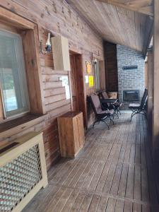 a porch of a wooden cabin with chairs and a fireplace at Karinna Orman Koskleri in Uludag