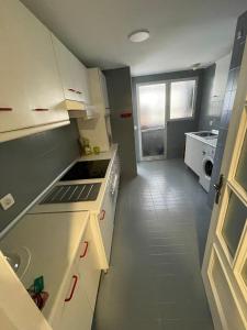 a kitchen with white cabinets and a stove top oven at RAYMAR HOUSE in Melilla