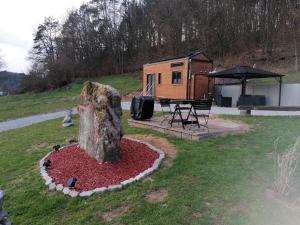 a tiny house with a tree stump in the yard at Au Petit Rocher in Roppeviller
