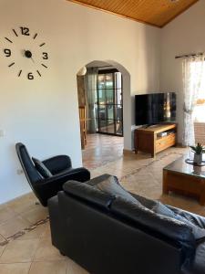 a living room with a couch and a clock on the wall at Villa 20 in Caleta De Fuste