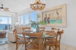 Un comedor con una mesa con sillas y un cuadro de pájaros. en Jade East Towers 0950 by Newman-Dailey, en Destin
