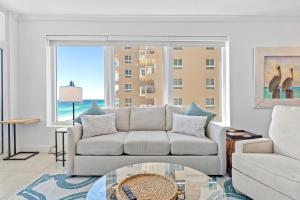 Una sala de estar con un sofá y una mesa de cristal. en Jade East Towers 0950 by Newman-Dailey, en Destin
