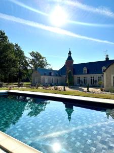 uma grande piscina em frente a uma casa em Domaine de charme - Les Places em Lassay-sur-Croisne