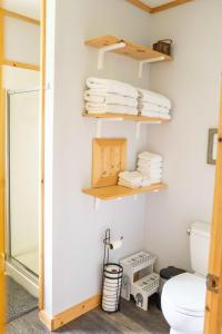 a bathroom with wooden shelves and a toilet at Cozy Cabin in Stratton Mountain & Mount Snow 10min in Stratton