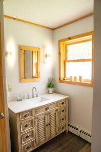 a bathroom with a sink and a window at Cozy Cabin in Stratton Mountain & Mount Snow 10min in Stratton