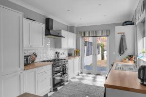 a kitchen with white cabinets and a stove at luxury Seaside Residence in Cleethorpes
