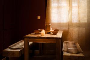 einen Holztisch mit Kerzen und einem Fenster in der Unterkunft Balda'Quand Médiéval in Carcassonne