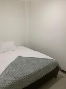 Bett in einem weißen Zimmer mit einer Matratze in der Unterkunft Hotel Portobello La Ceja in La Ceja