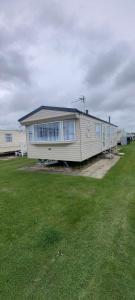 a small house in a yard with a green field at Golden Palm Resort Sherwood 6 Berth Club Tropicana Chapel St Leonards in Skegness