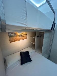 Cama elevada en habitación pequeña con ventana en Mini Rooms By Illusion en Playa del Carmen