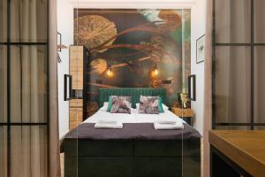 a bedroom with a bed with a painting on the wall at Prestige Apartments 19 in Wrocław