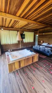 Großes Zimmer mit Whirlpool und Bett in der Unterkunft Villa Gatto Chalés - Visconde de Maua in Bocaina de Minas