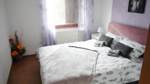 um quarto com uma grande cama branca com almofadas em Kuća za Odmor Naša Priča em Šipovo