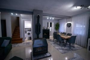 a living room with a fireplace and a dining room at Villa KIKO Mountain Village in Bitola