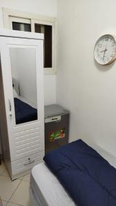 ein Schlafzimmer mit einem Bett und einer Uhr an der Wand in der Unterkunft Loaloat El Sharjah for women in Schardscha