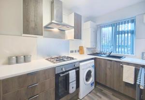 a kitchen with a washer and dryer in it at Dalesman Apartment - 10 Minutes Walk to Manchester City Centre, Oxford Road, Chinatown, Universities in Manchester