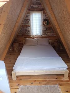a bed in a loft with a window at Litost Cafe in Adrasan