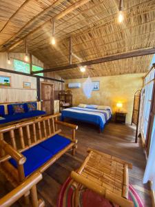 a bedroom with two beds and benches in a room at Los Amigos Ecoturismo y Reserva Natural in Catemaco