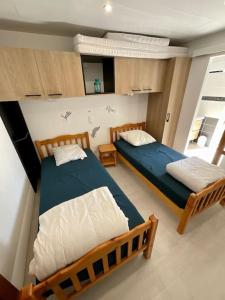 a bedroom with two beds and a mirror at Chaleureuse maisonnette avec piscine partagée in Capbreton