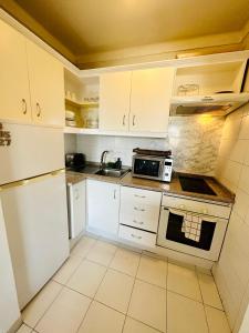 a kitchen with white cabinets and a microwave at Sunny Sea View Apartment Center of Las Americas in Playa de las Americas +48 photos