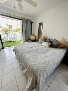 a large bed in a bedroom with a large window at Sunny Sea View Apartment Center of Las Americas in Playa de las Americas