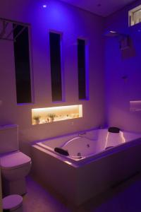 Cortume的住宿－Rancho do Sena Lazer e Eventos，紫色浴室设有浴缸和卫生间