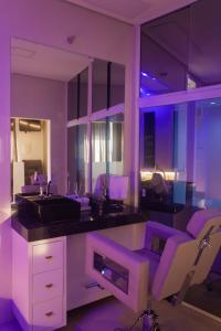 Cortume的住宿－Rancho do Sena Lazer e Eventos，厨房配有紫色照明、水槽和椅子