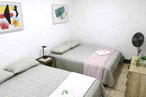 Un dormitorio con dos camas y una mesa con lámpara. en Casa Colibrí Apartamento 3, en Guatemala