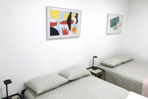 Un dormitorio con dos camas y un cuadro en la pared. en Casa Colibrí Apartamento 3, en Guatemala