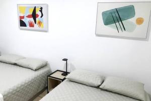 Un dormitorio con dos camas y una mesa con lámpara. en Casa Colibrí Apartamento 3, en Guatemala