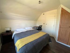 ein Schlafzimmer mit einem Bett, einem Tisch und einem Stuhl in der Unterkunft Casa full Interior in Castro