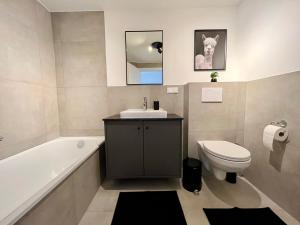 uma casa de banho com um lavatório, um WC e uma banheira em *TOP* Moderne Wohnung - Nähe Köln: Dom, Messe, Flughafen, Lanxess-Arena em Bergisch Gladbach
