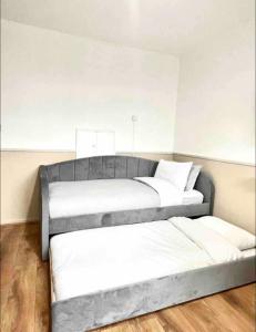 Duas camas num quarto com paredes brancas e pisos em madeira em Holiday apartment Central London em Londres
