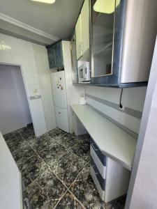 una pequeña cocina con encimera y nevera en Coqueto Apartamento, en Martos