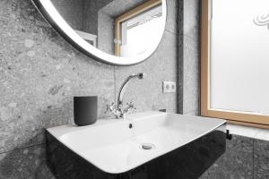 a bathroom with a sink and a mirror at Apart Feine Zeit - Apartment Wiesele in Schönwies
