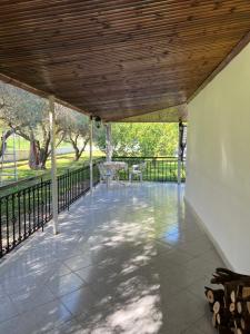 a porch with a wooden roof and a table and chairs at Lina's Residence in Stavros